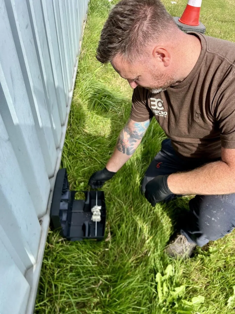 Bawcro Pest Control technician setting up baited rat traps in a commercial property to mitigate infestation risks.